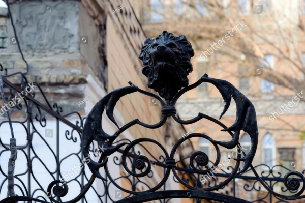 Pagar besi dengan ornamen hiasan kepala singa